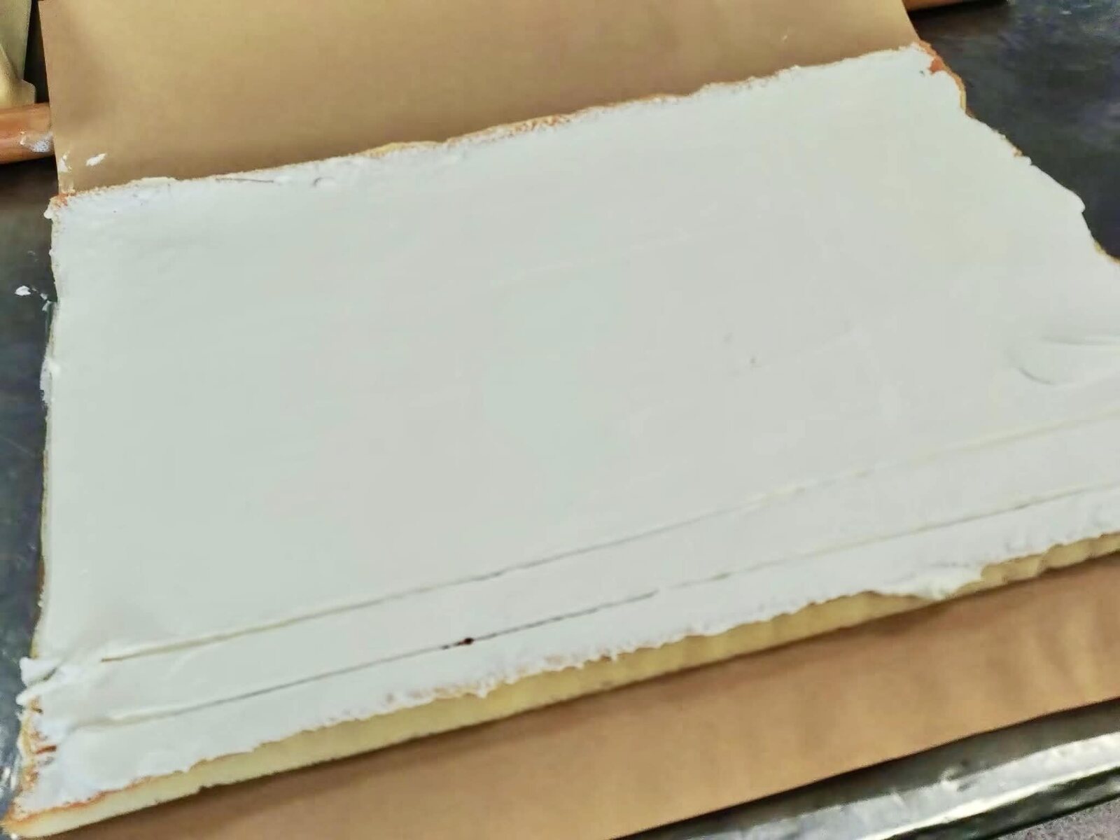 ロールケーキの生地に生クリームを広げる工程