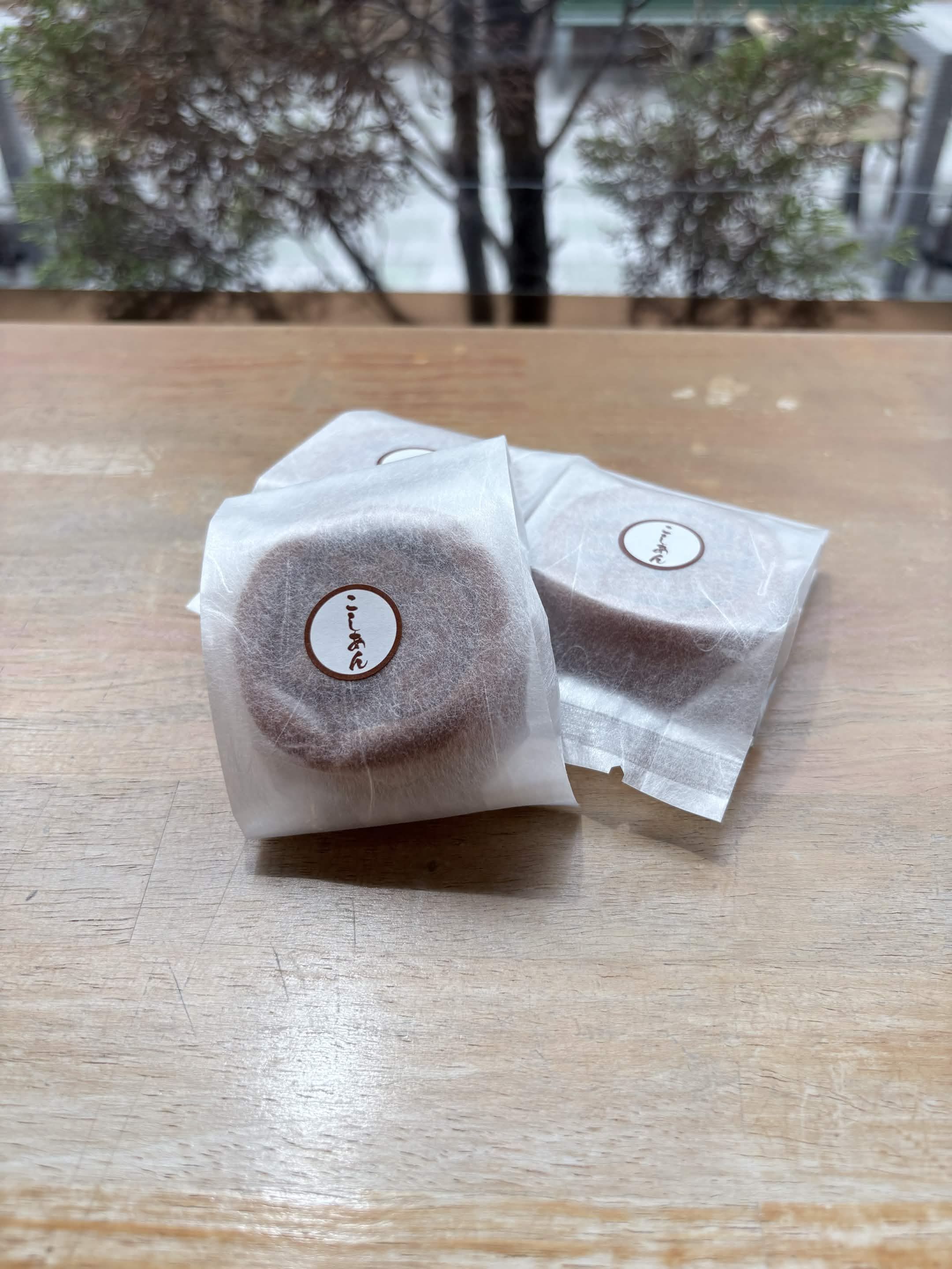 木のテーブルに置かれた個包装の高原まんじゅう